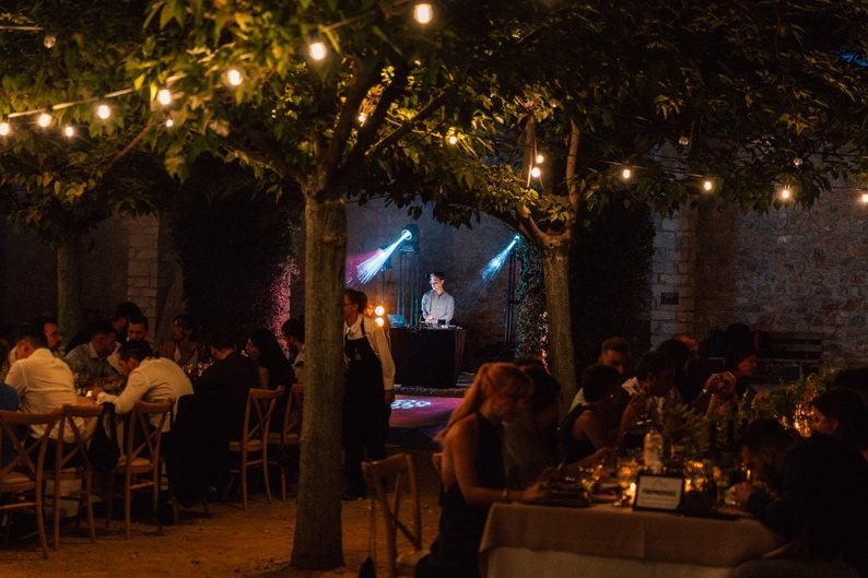 Dinner under string lights with the DJ booth